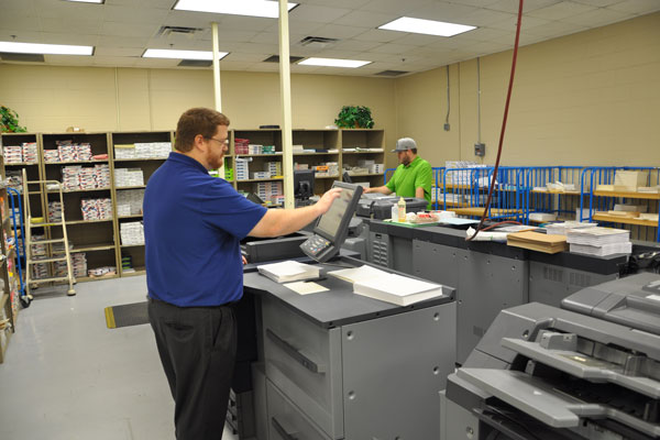 a man check the printer in a printing shop